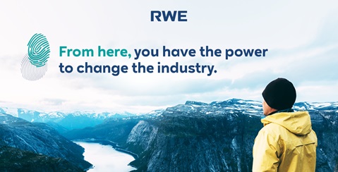 Ein Mann in einer gelben Jacke steht im Freien und blickt auf eine beeindruckende Berglandschaft mit einem Slogan von RWE.