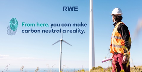 A worker in an orange vest stands in front of a wind turbine, promoting renewable energy.