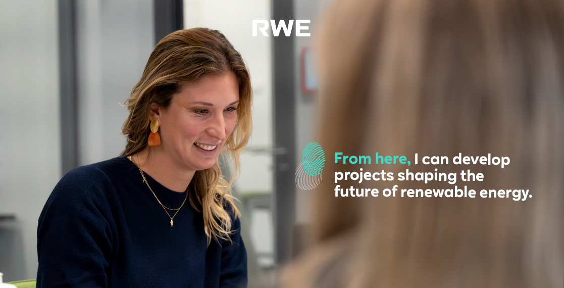 A woman with earrings listens attentively in a modern office, reflecting on renewable energy projects.