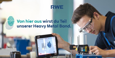 Junger Mann, der ein Tablet benutzt, um eine technische Komponente zu überprüfen, während er in einer Werkstatt arbeitet.