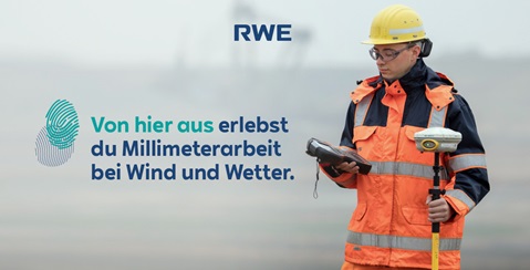 Ein Arbeiter in orangefarbener Kleidung hält ein Messgerät in der Hand. Hintergrund ist neblig und unscharf.