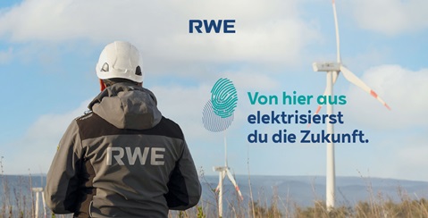 Ein RWE-Mitarbeiter mit Helm blickt auf Windkraftanlagen in der Natur. Der Slogan betont grüne Energie für die Zukunft.