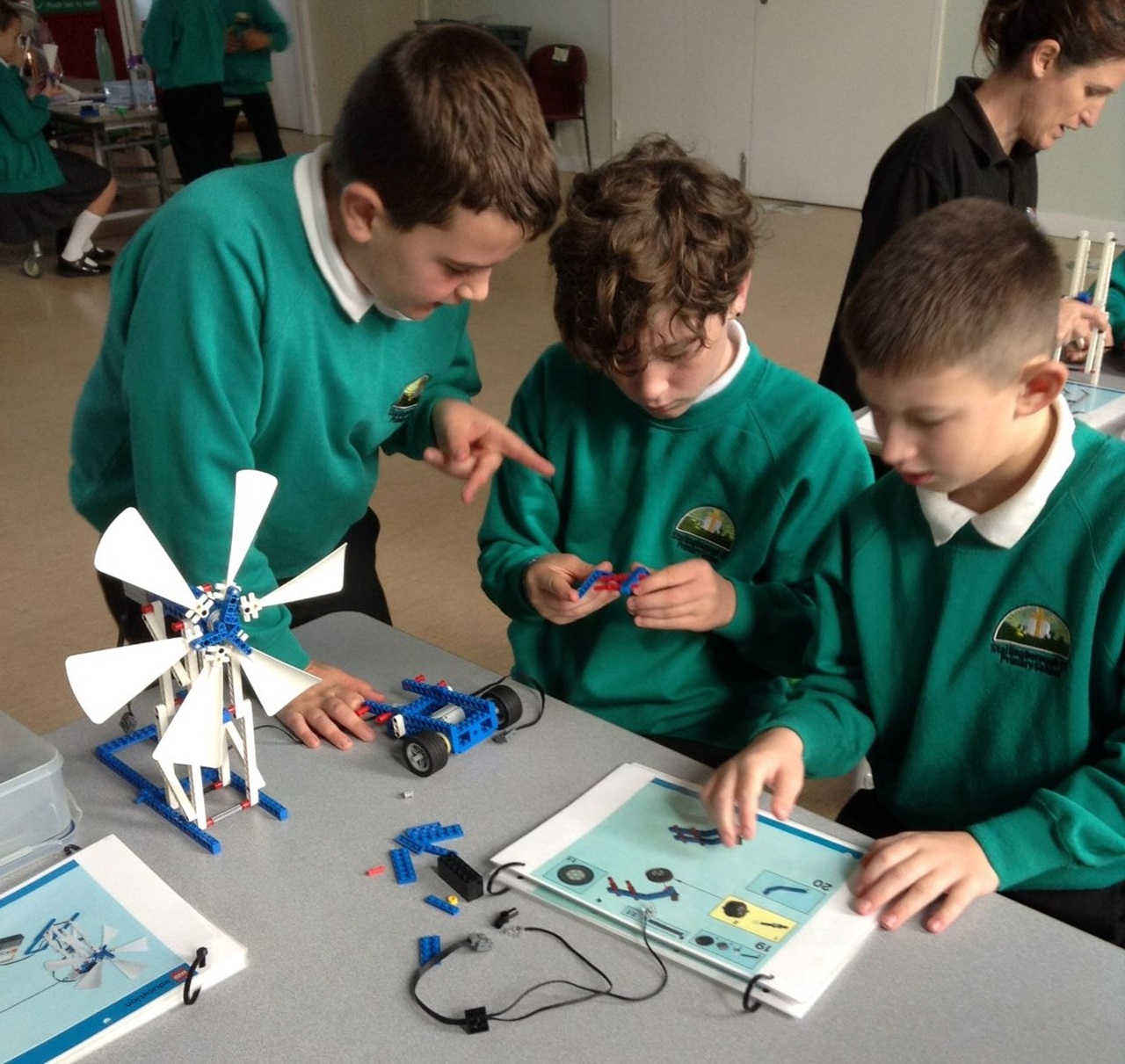 Students collaborating on building a model turbine from LEGO pieces in a classroom.