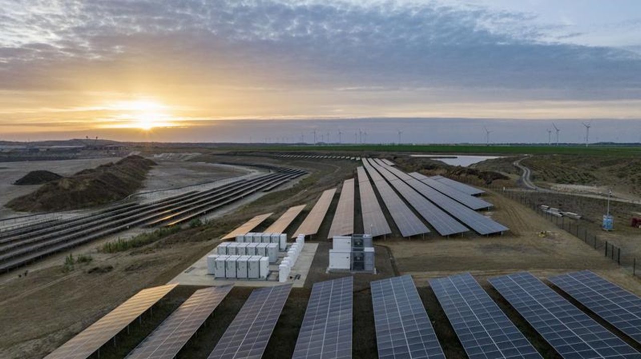 Eine Solaranlage mit Reihen von Solarpanelen und Energiespeichereinheiten, die im Sonnenuntergang erstrahlen.