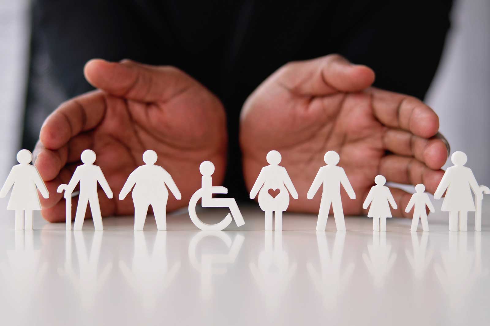 Two hands surround a row of white figures representing diverse individuals with various characteristics.