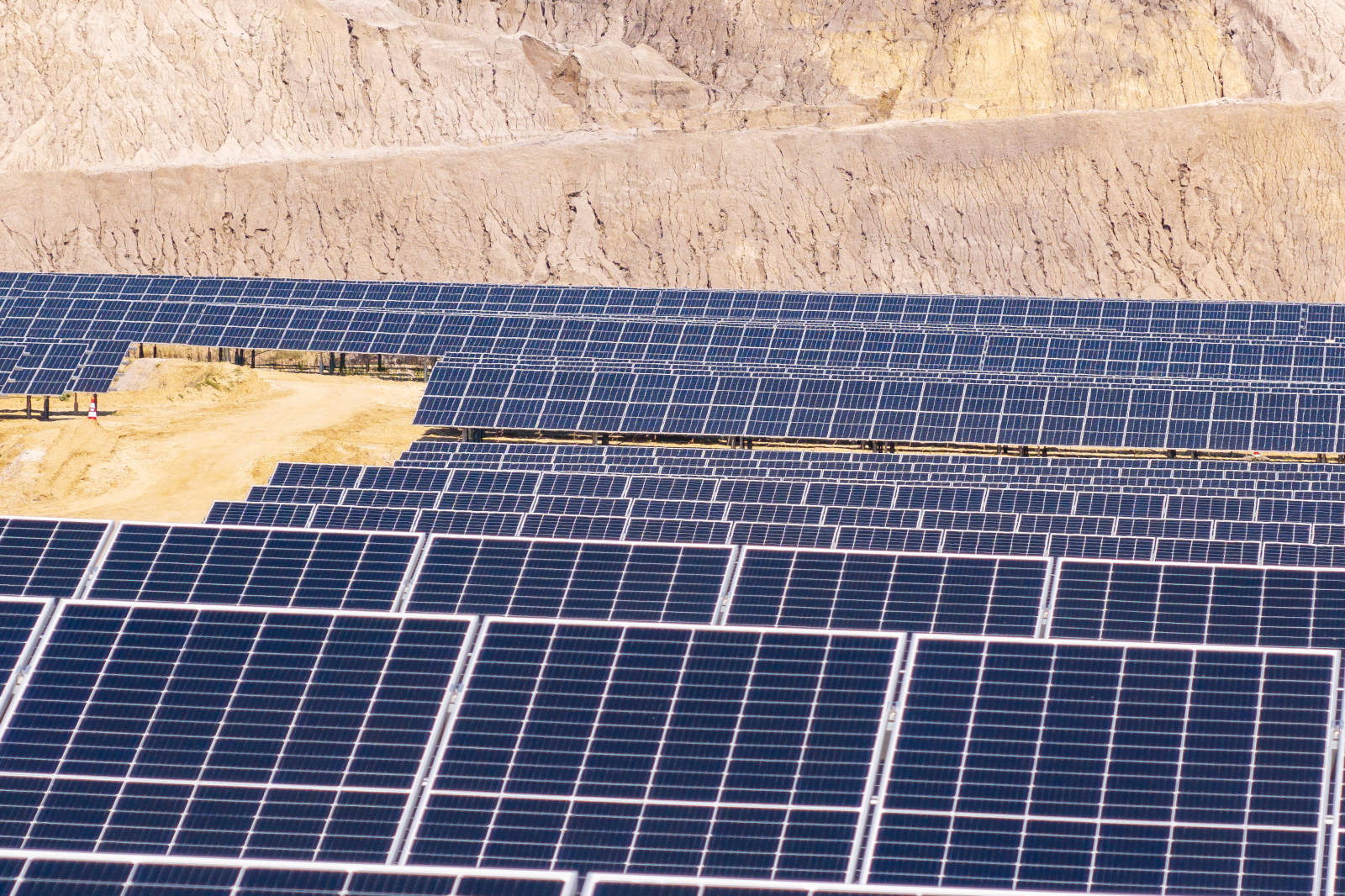 Ein großes Solarkraftwerk mit vielen Solarpanels auf einer trockenen Landschaft.