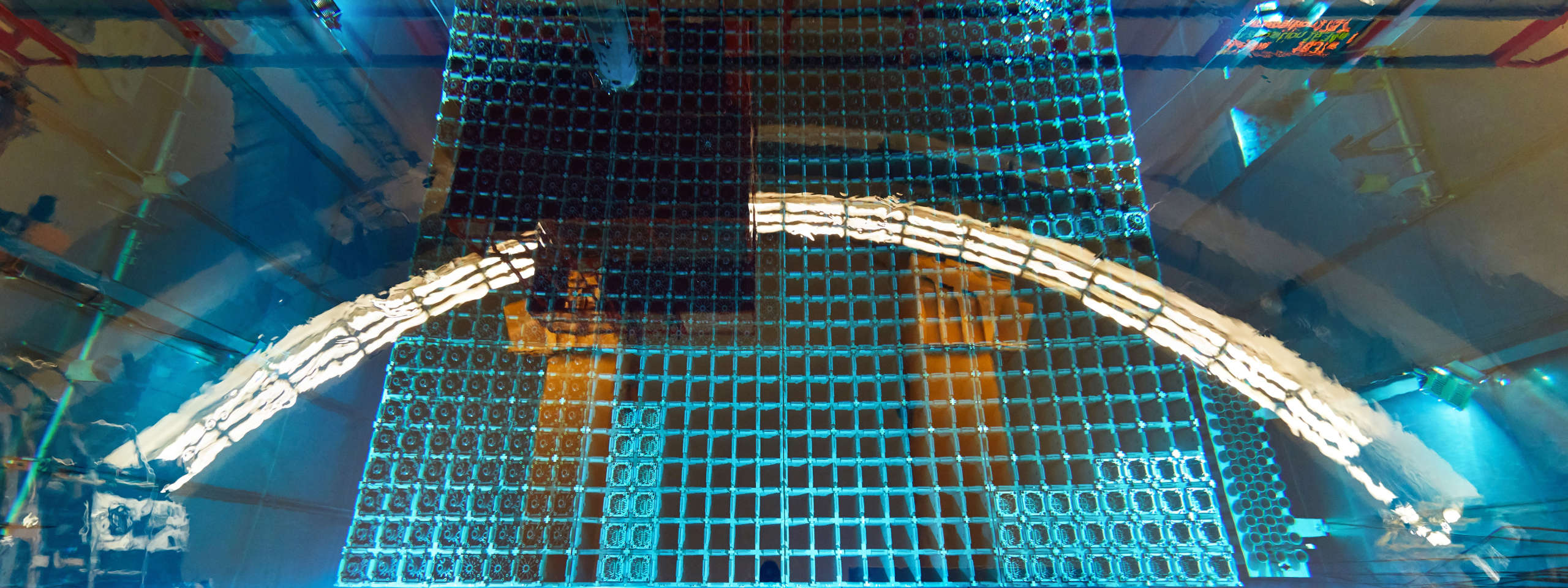 Eine Draufsicht auf eine blau gefärbte gitterartige Struktur, möglicherweise ein Pool oder Tank mit Wasser und mechanischen Komponenten.