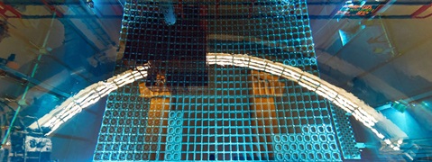 Eine Draufsicht auf eine blau gefärbte gitterartige Struktur, möglicherweise ein Pool oder Tank mit Wasser und mechanischen Komponenten.