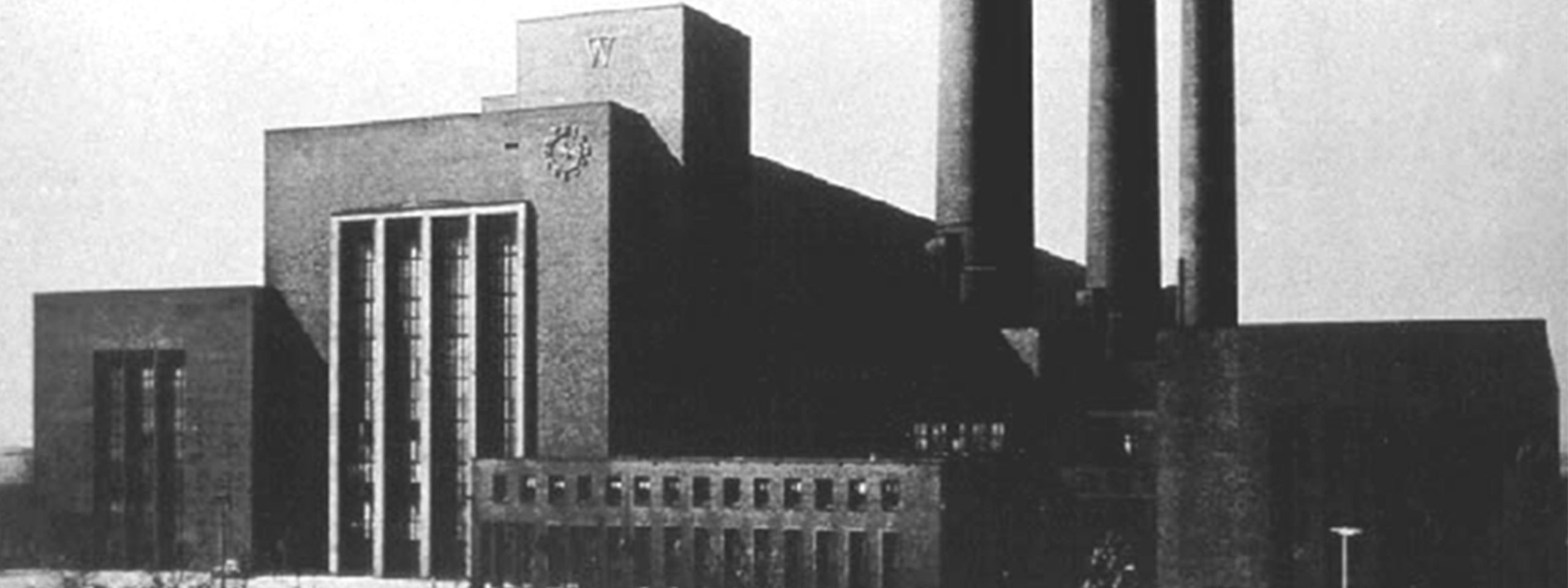 Ein imposantes Industriegebäude mit zwei Schornsteinen und markanten architektonischen Details.