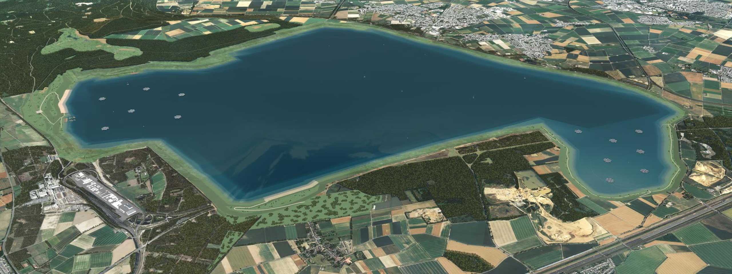 Luftaufnahme eines großen Sees, umgeben von Feldern und Wäldern, mit kleinen Booten auf dem Wasser.