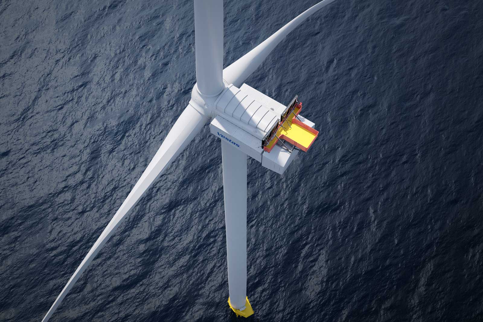 A wind turbine stands over the ocean, featuring a red and yellow access platform on top of the nacelle.