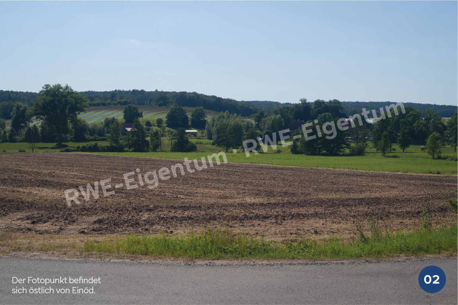 Ein weitläufiges Feld mit bearbeitetem Boden und Wald im Hintergrund, der Fotopunkt befindet sich östlich von Einöd.