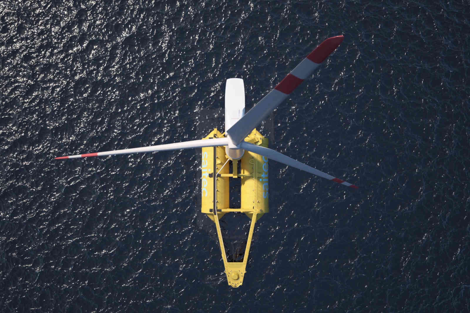 An aerial view of a yellow wind turbine with white and red blades over water.