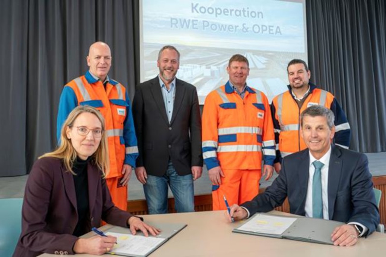 Geschäftsvertreter unterzeichnen eine Kooperationsvereinbarung bei einer formellen Veranstaltung, mit einem Banner im Hintergrund.