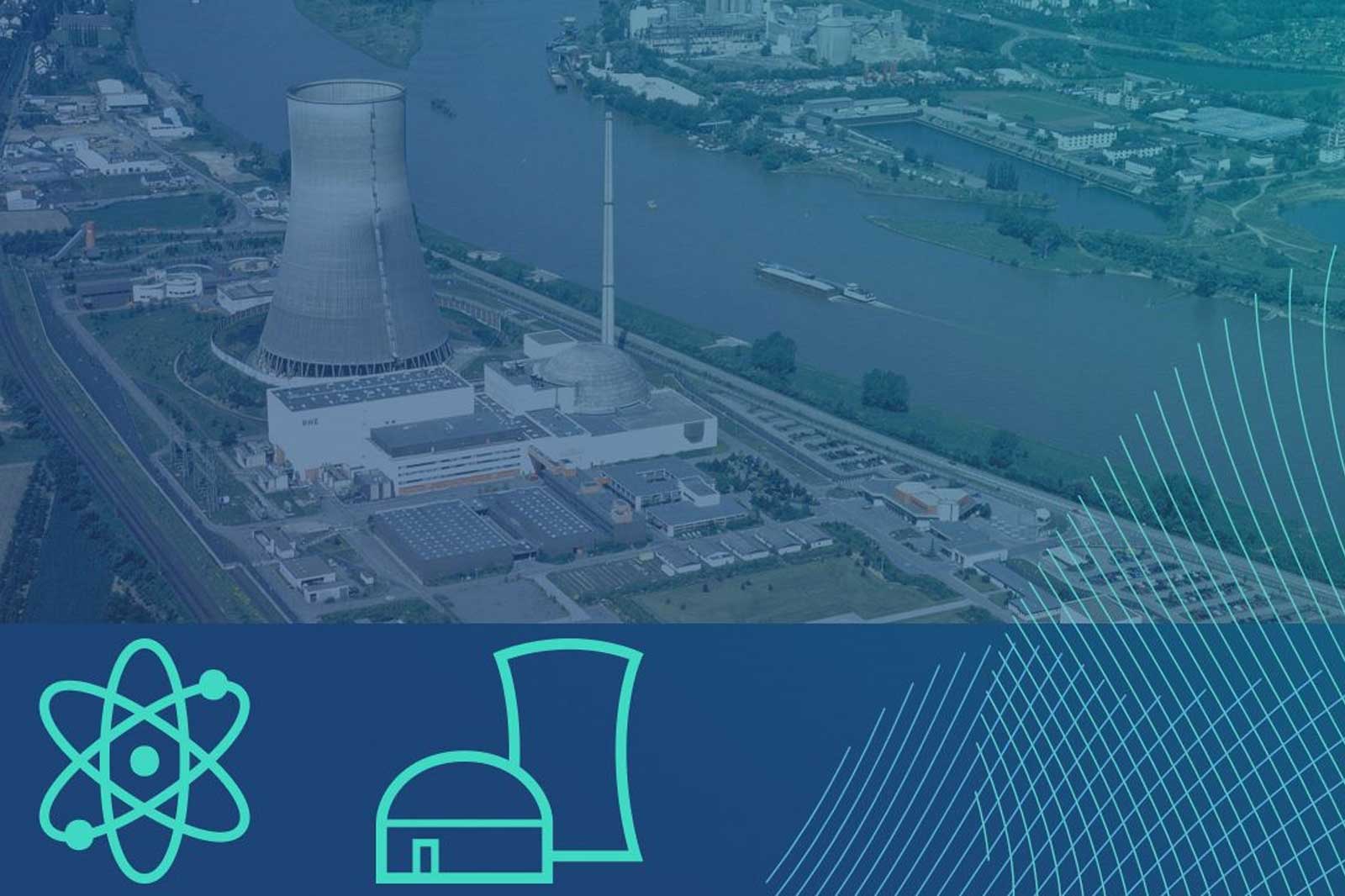 An aerial view of a nuclear power plant beside a river, with cooling towers and various industrial buildings visible.