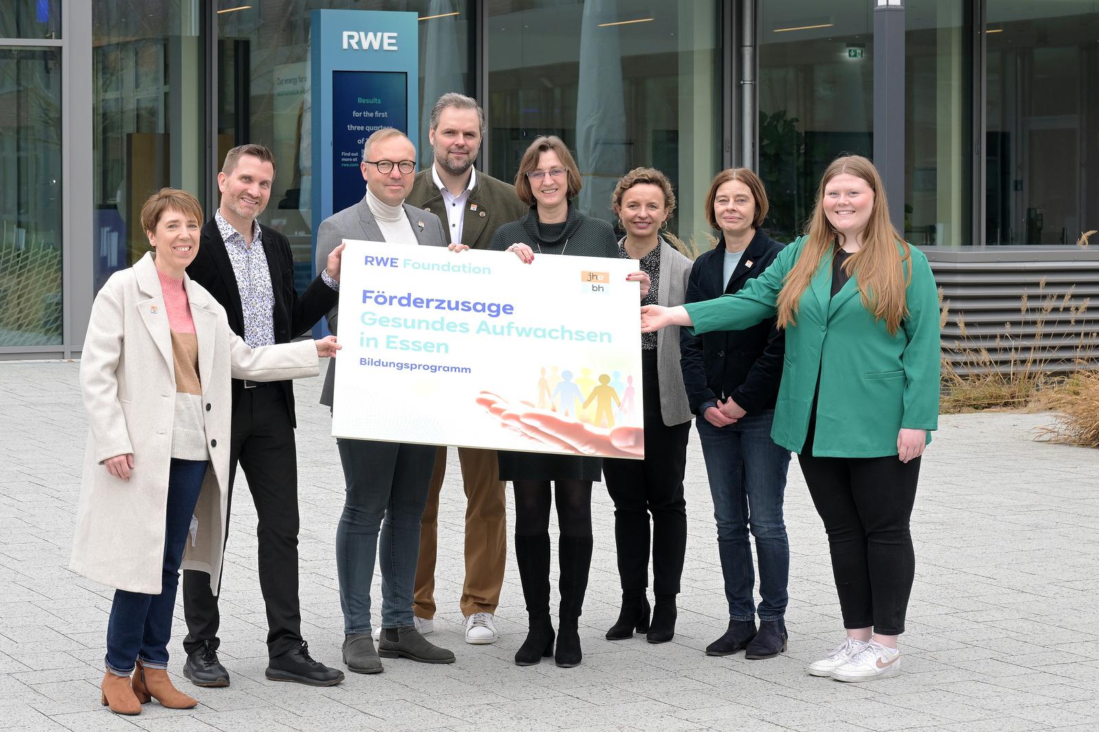 Eine Gruppe von Personen hält ein Schild für ein Bildungsprogramm der RWE-Stiftung in Essen.