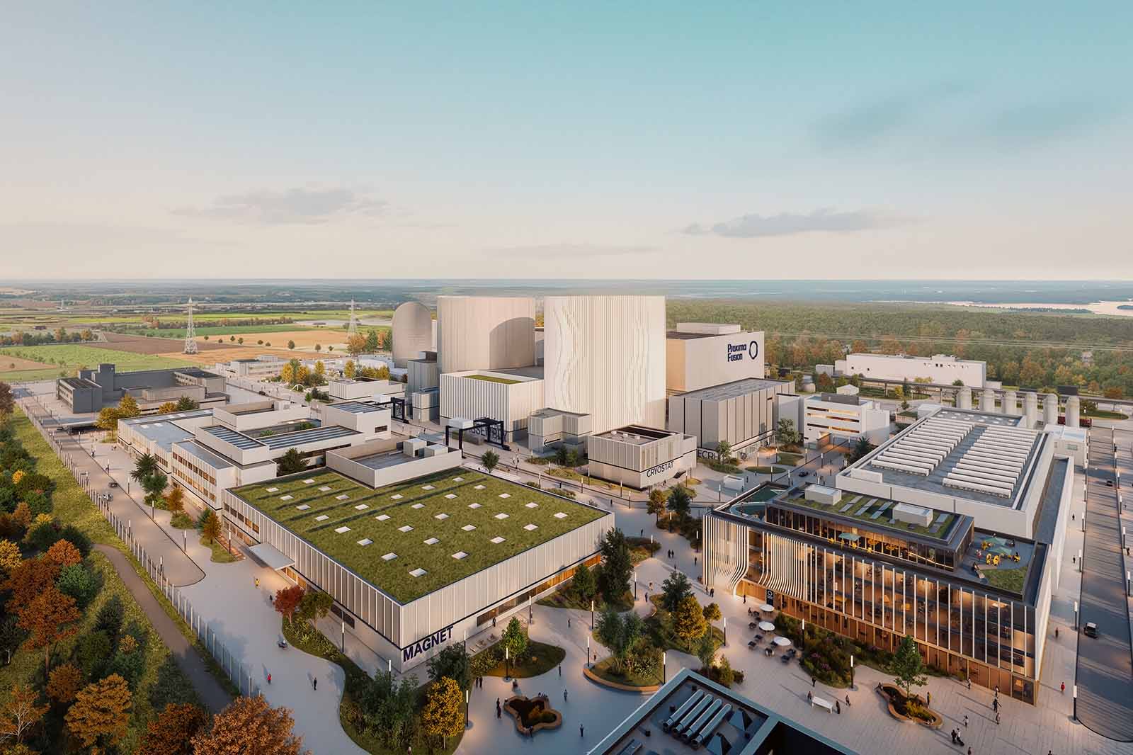 Luftaufnahme eines modernen Industrieareals mit großen sandfarbenen Beton- und Glasbauten, begrüntem Dach, baumbestandenen Wegen und hellem blauen Himmel.