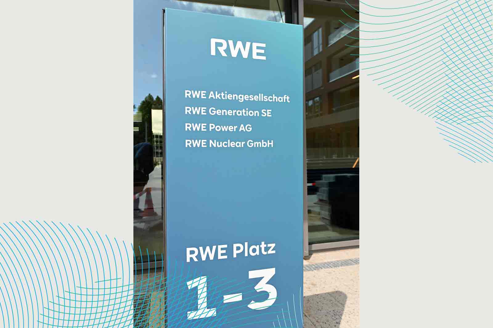 Das Schild zeigt RWE-Aktiengesellschaft und ihre Tochtergesellschaften mit der Aufschrift 'RWE Platz 1-3'.