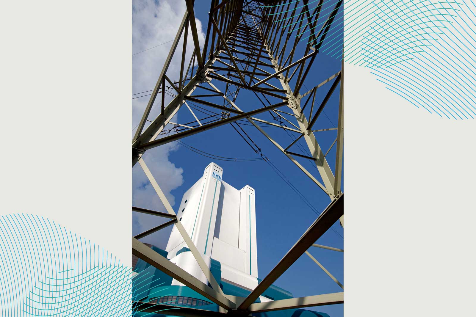 Eine Sicht von unten auf einen metallischen Turm zu einem weißen Gebäude vor einem blauen Himmel mit Wolken.