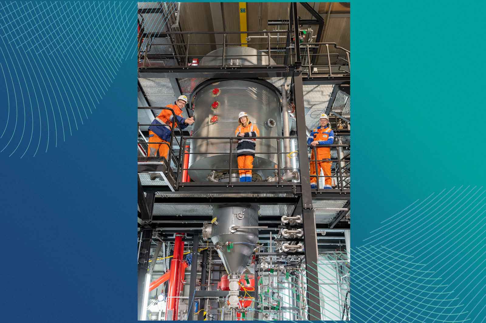 Arbeiter in orange Overalls bedienen Maschinen in einer industriellen Einrichtung mit Metallkonstruktionen und Rohrleitungen um sie herum.