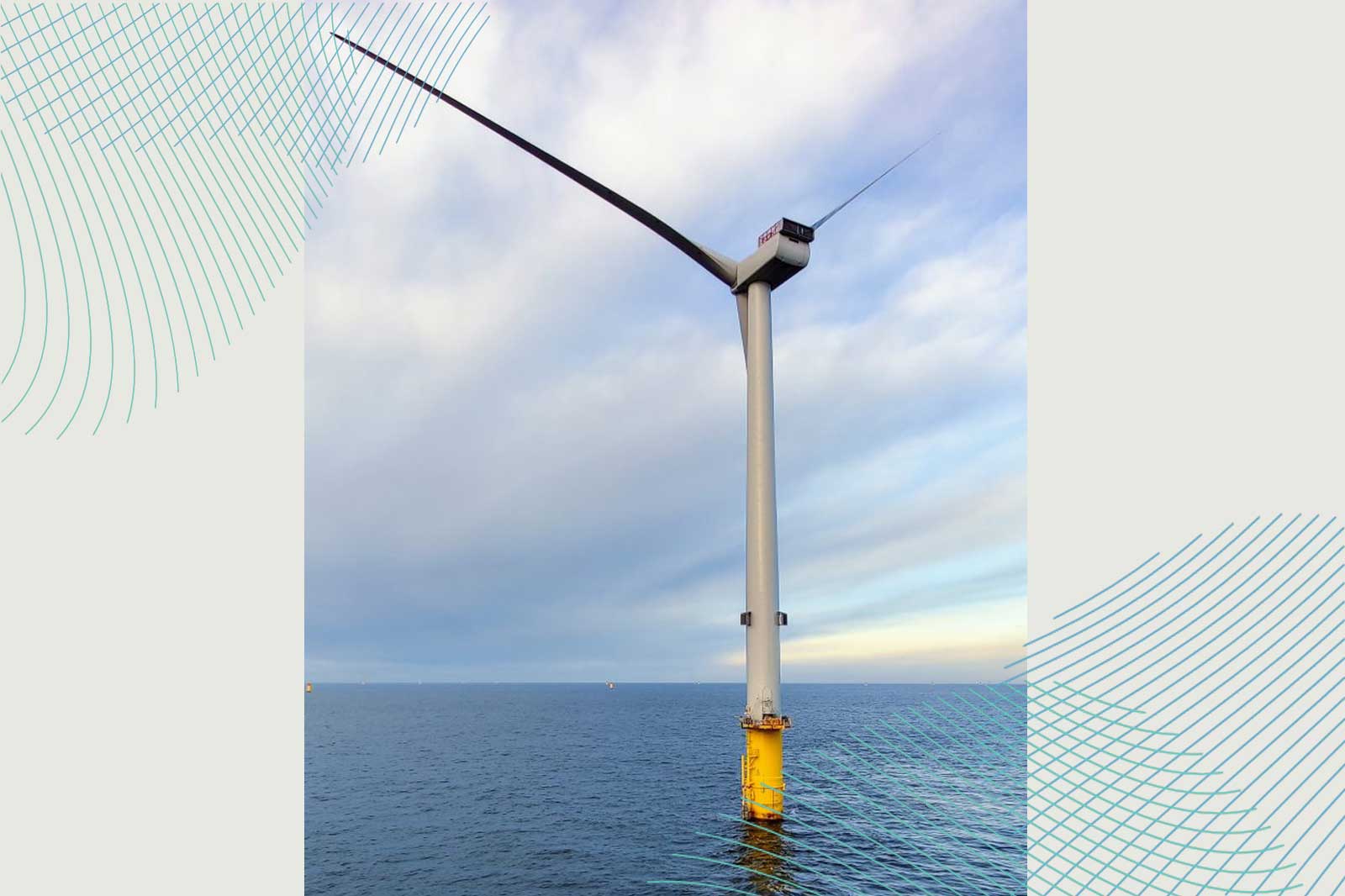 A tall offshore wind turbine standing in calm seas under a cloudy sky, with a bright yellow base and dark blades.