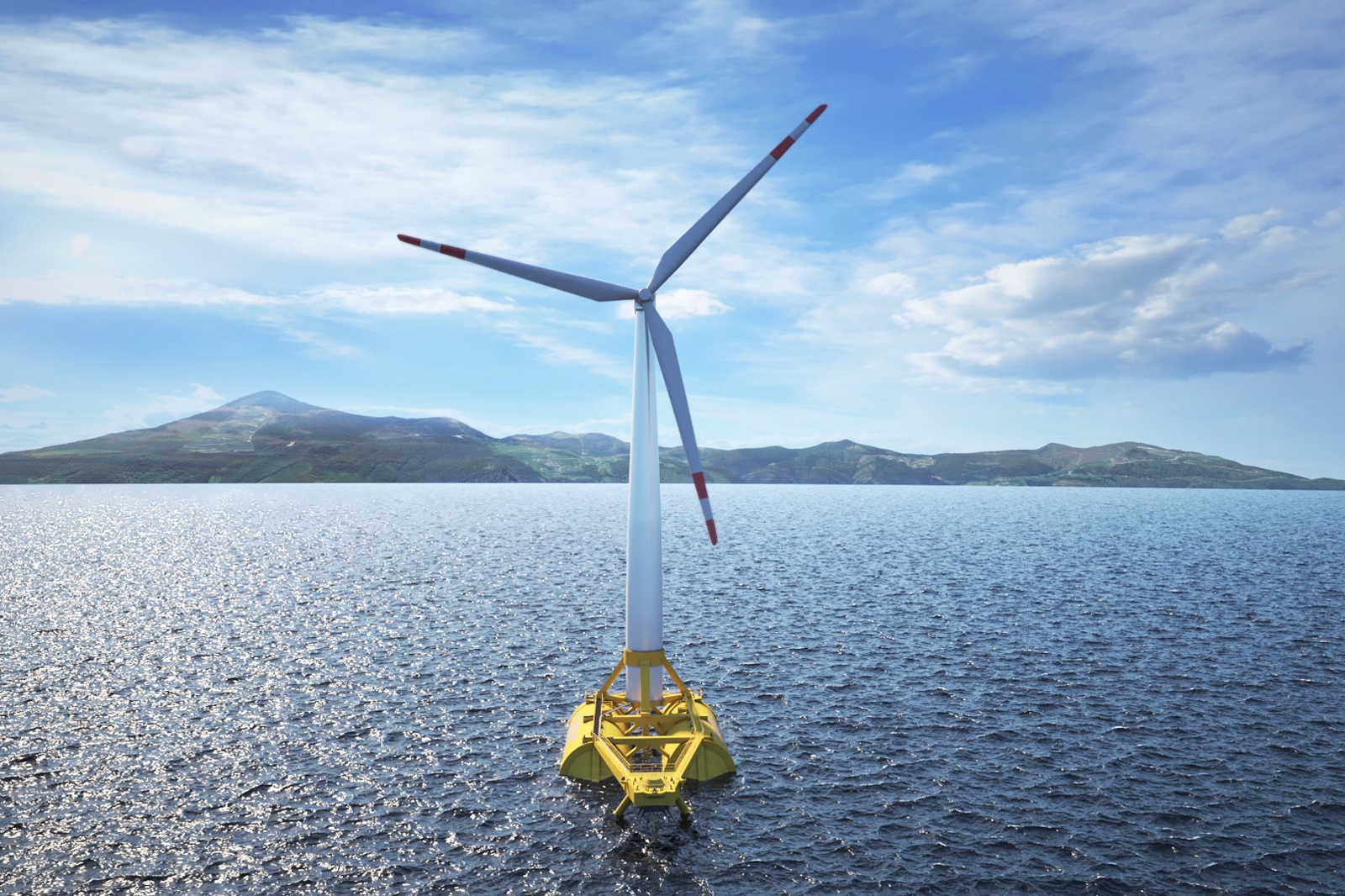 A floating wind turbine in the sea, with a mountainous landscape in the background under a bright blue sky.
