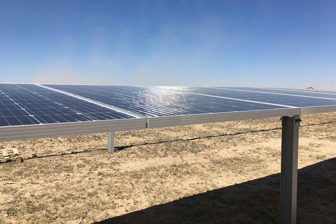 Ein Solar-Paneel auf einem Feld, reflektiert Sonnenlicht unter blauem Himmel.