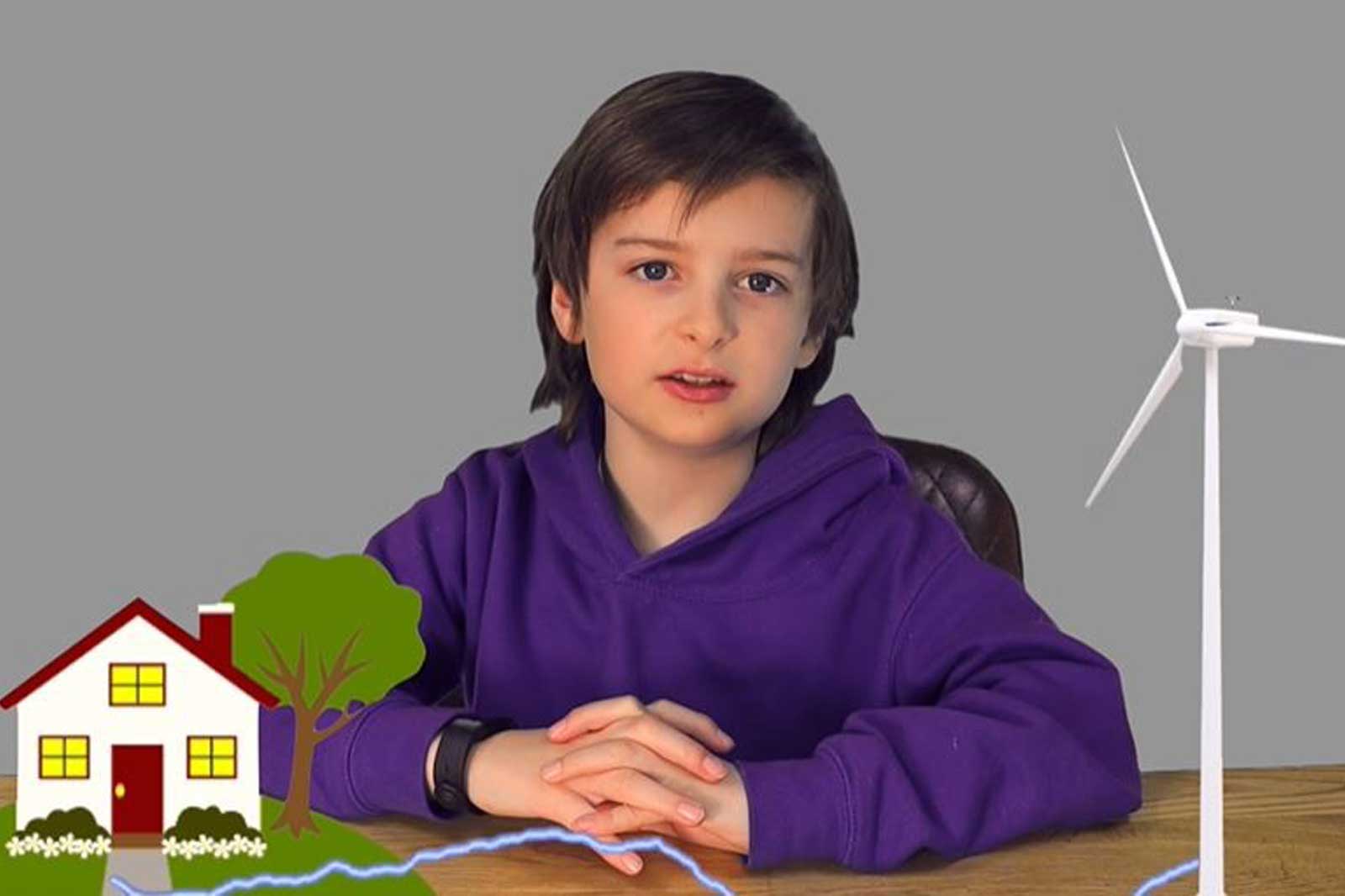 A child in a purple hoodie sits at a table, with a house and wind turbine illustration beside them against a grey background.