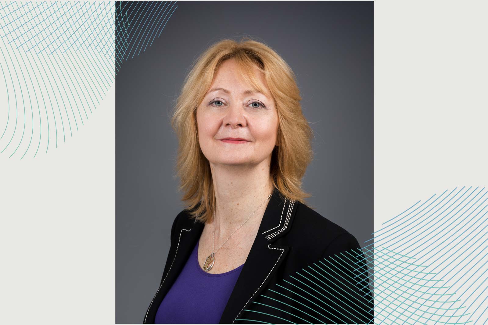 A woman with medium-length wavy blonde hair wears a black blazer over a purple top. The background features subtle graphic lines.