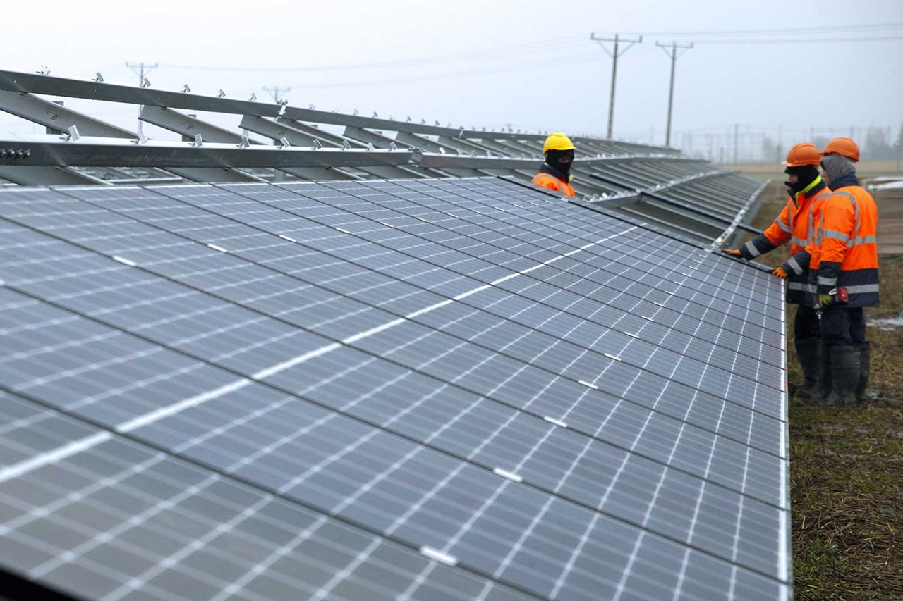Arbeiter installieren Solarpanele auf einem Feld, umweltfreundliche Energiegewinnung.