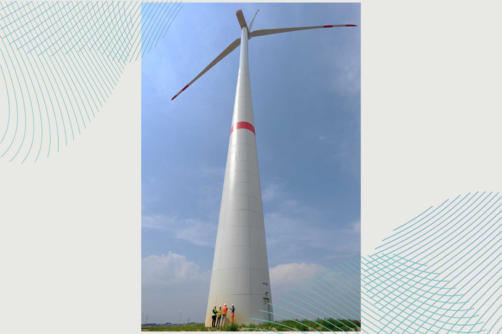 Eine große Windturbine steht im Vordergrund, während Fachleute darunter stehen und sie inspizieren.