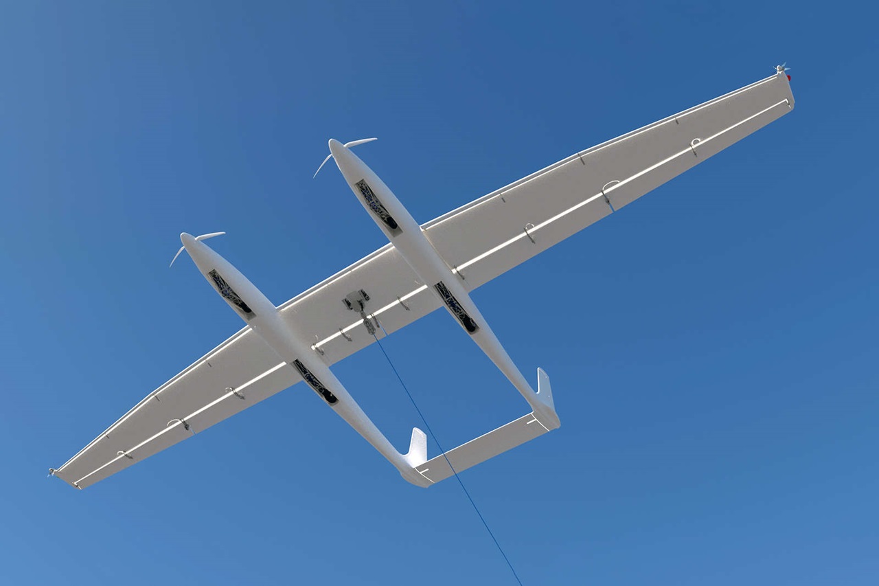 A white aircraft with two wings is soaring beneath a blue sky.
