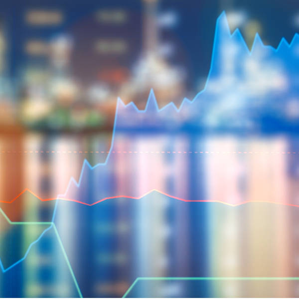 Grafik mit bunten Linien und Farbschemata, die einen aufsteigenden Trend zeigen, im Hintergrund unscharfe Gebäude.