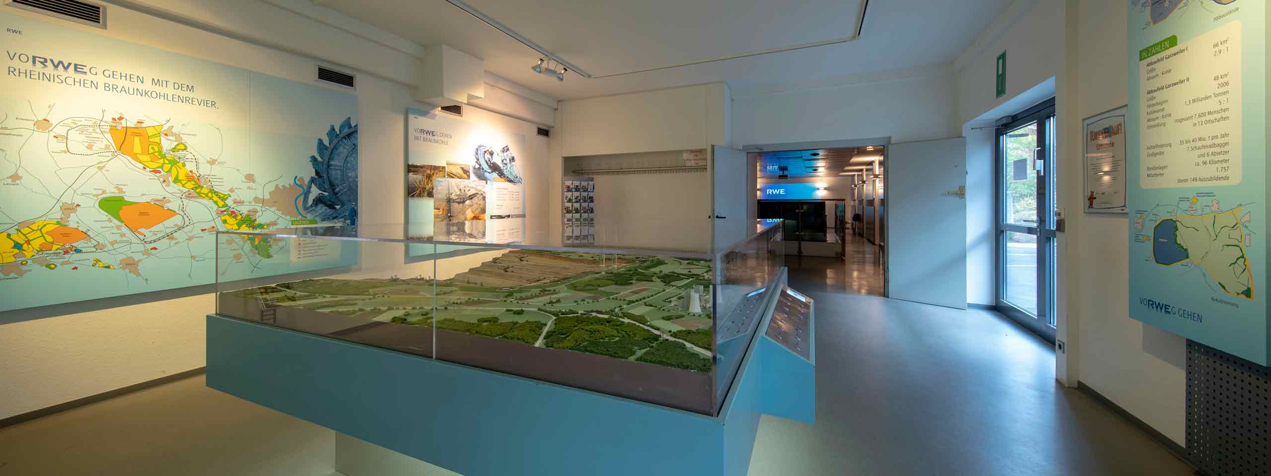 Ein moderner Raum mit einem 3D-Modell der Landschaft und Informationswänden über das Braunkohle-Revier.
