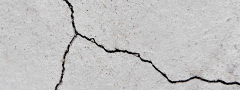 Ein Riss im Beton ist sichtbar, der sich unregelmäßig über die Oberfläche zieht.