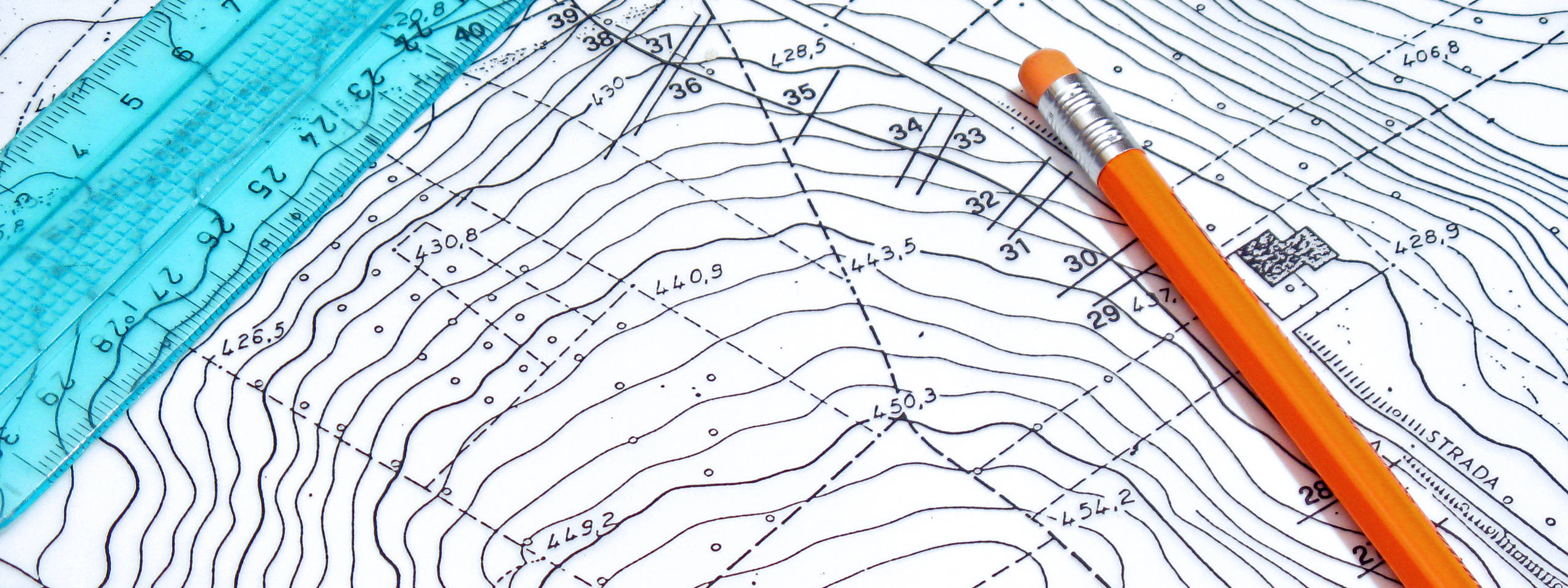 Eine Detailansicht einer Karte mit Höhenlinien, einem blauen Lineal und einem orangefarbenen Bleistift.