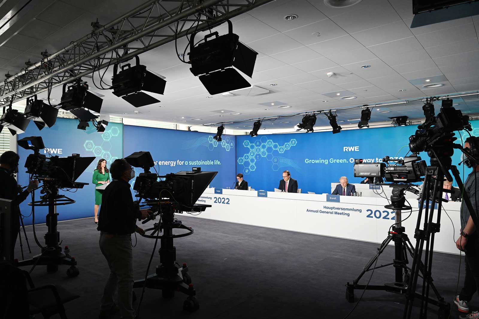 RWE Hauptversammlung 2022 mit einer grünen Kulisse und Kamerateams, die die Veranstaltung aufzeichnen.
