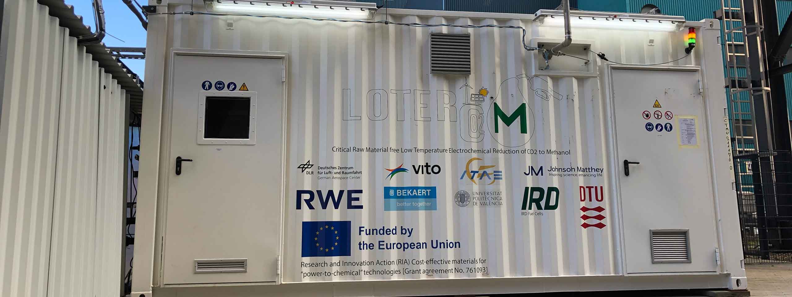 Ein Forschungscontainer, der eine elektrochemische CO₂-Reduktionsanlage zeigt, mit mehreren Logos auf der Außenseite.