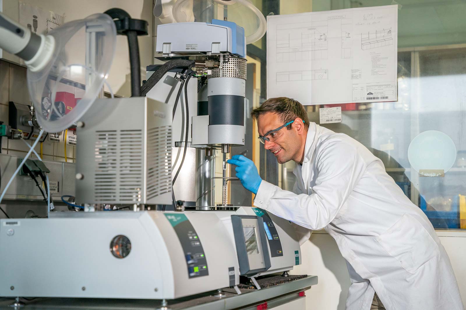 Ein Wissenschaftler in einem Labor, der an einem Geräteset mit mehreren Monitoren arbeitet.