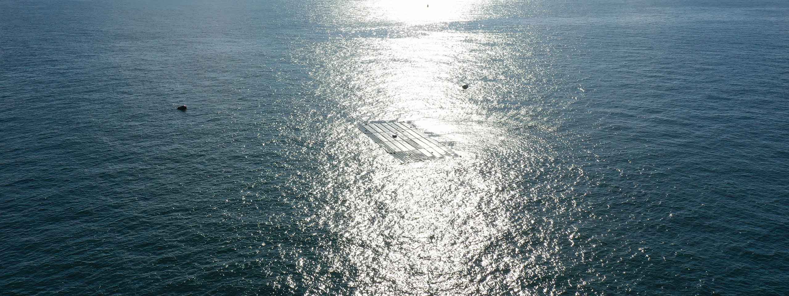 Ein Sonnenstrahl spiegelt sich auf dem Wasser, mit einem Solarmodul, das teilweise untergetaucht ist.