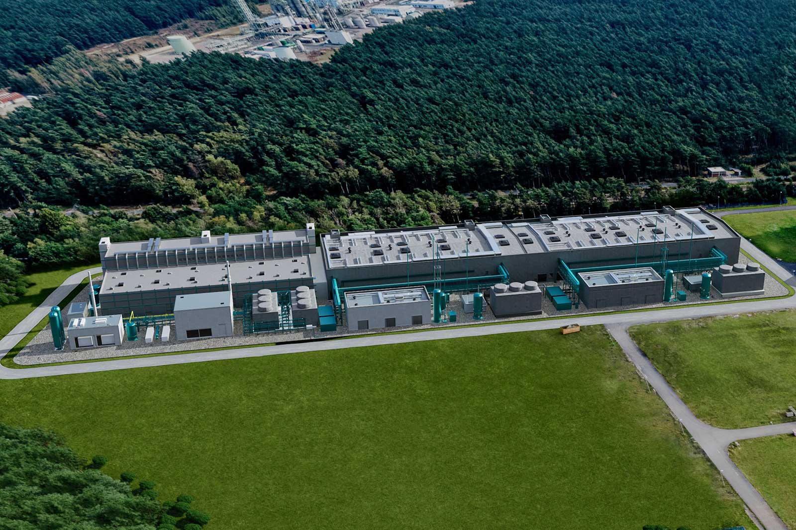 Aerial view of an industrial facility featuring modern structures, surrounded by forests and open fields.
