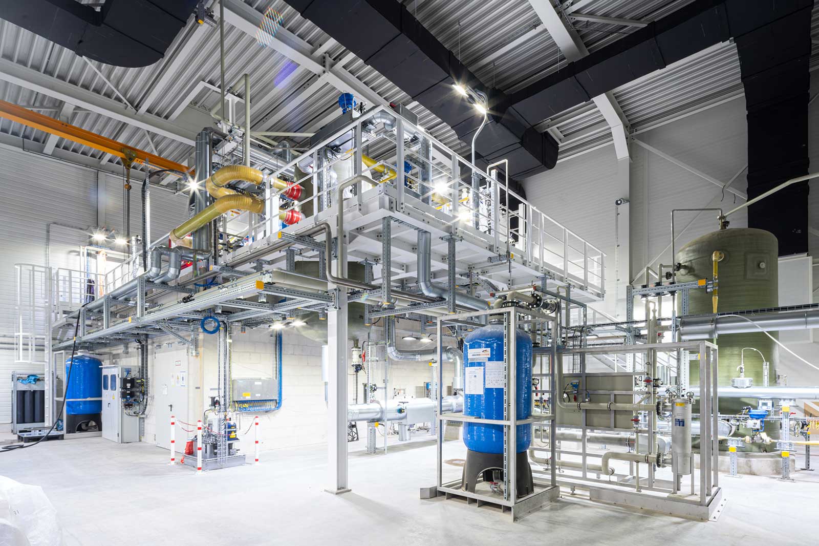 Eine moderne Industrieanlage mit Rohren, Tanks und Leitungen in einem hellen, geräumigen Raum.