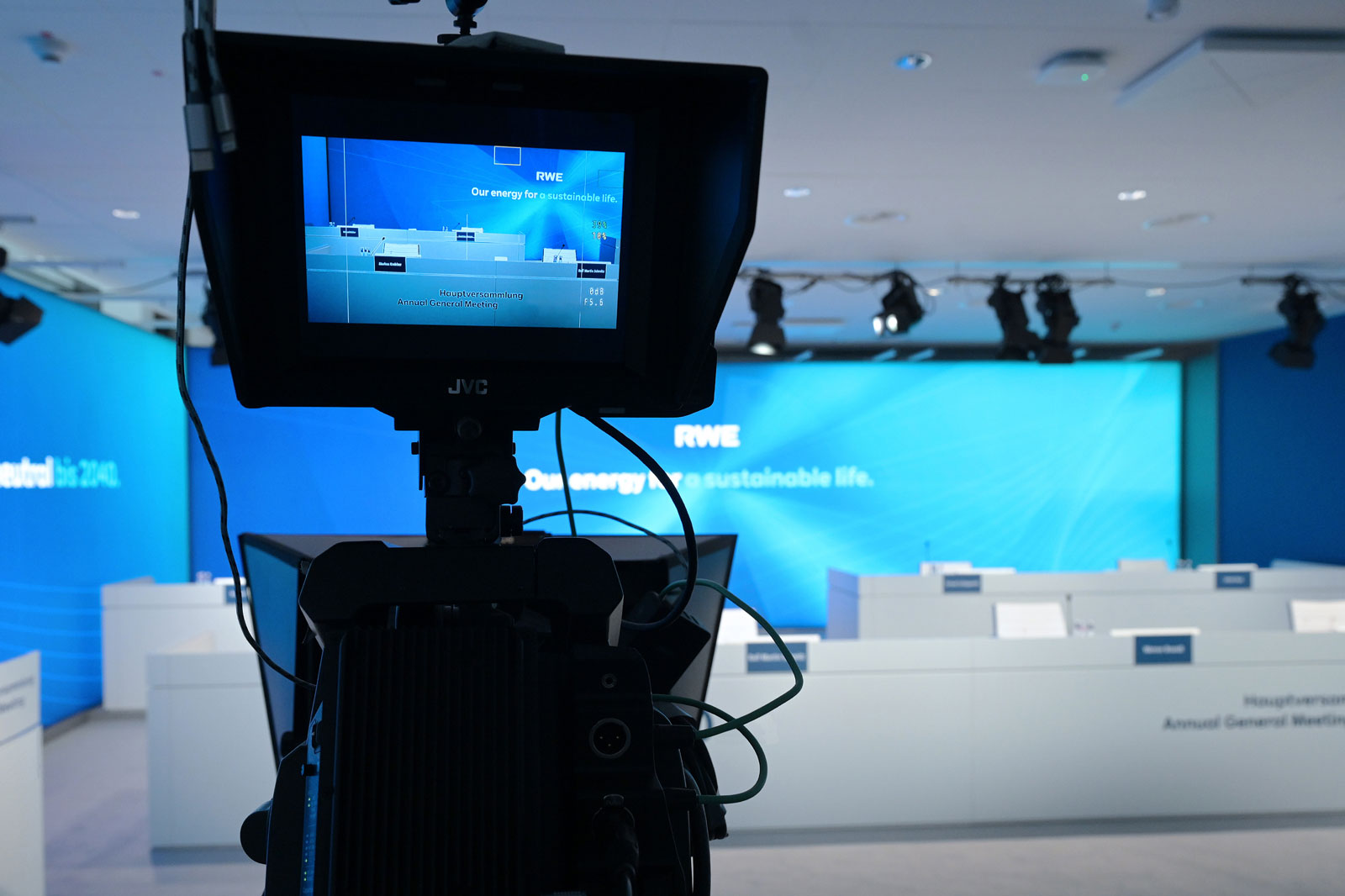 Ein Kamerablick auf einen Veranstaltungsraum mit RWE-Materialien zur nachhaltigen Energie. Moderner Hintergrund.