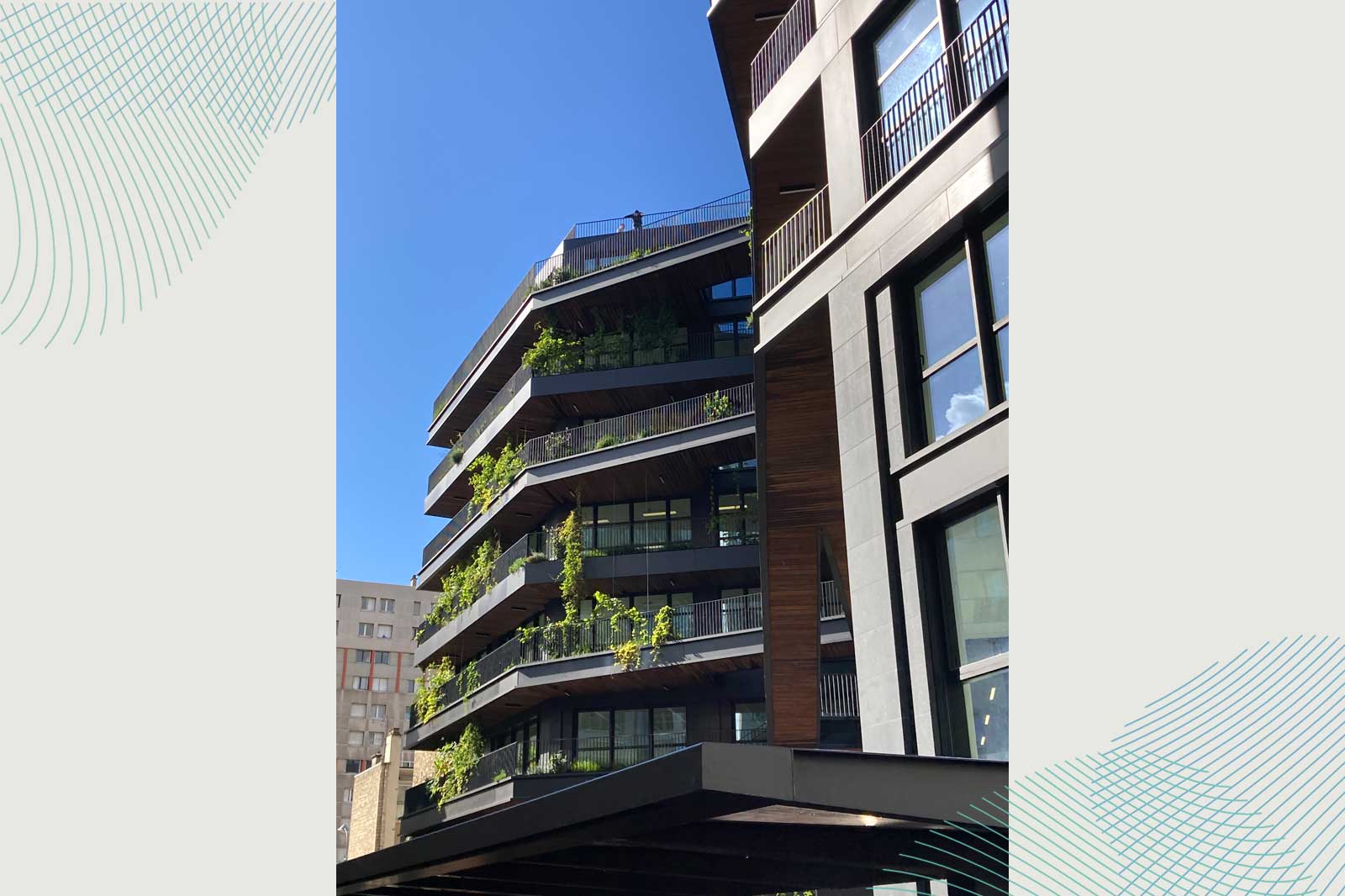 Moderne Gebäude mit Terrassen, die mit Pflanzen bedeckt sind, vor blauem Himmel.