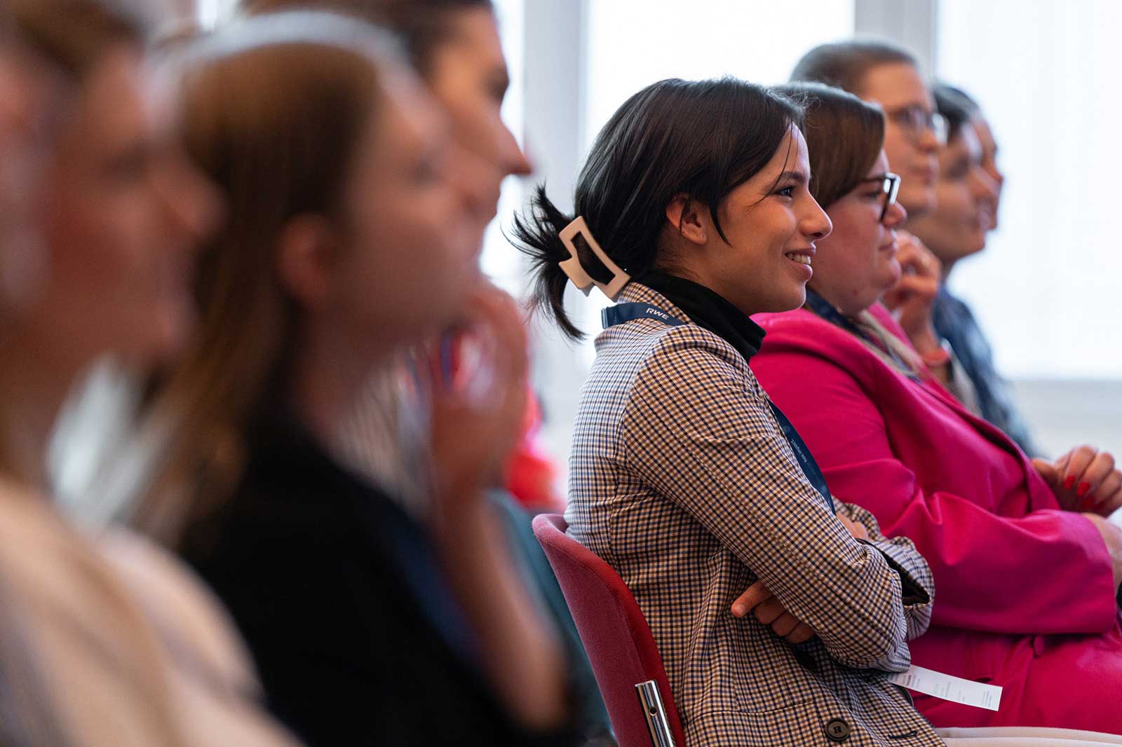 Die Bilder zeigen eine Gruppe von Personen, die in einem Seminar oder einer Konferenz aufmerksam zuhören.