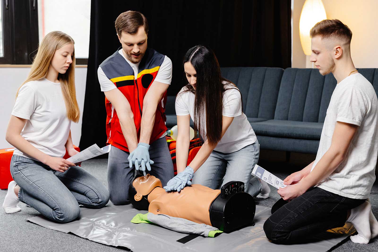 Eine Gruppe übt CPR an einer Schulungsanatomie in einem gut beleuchteten Raum.