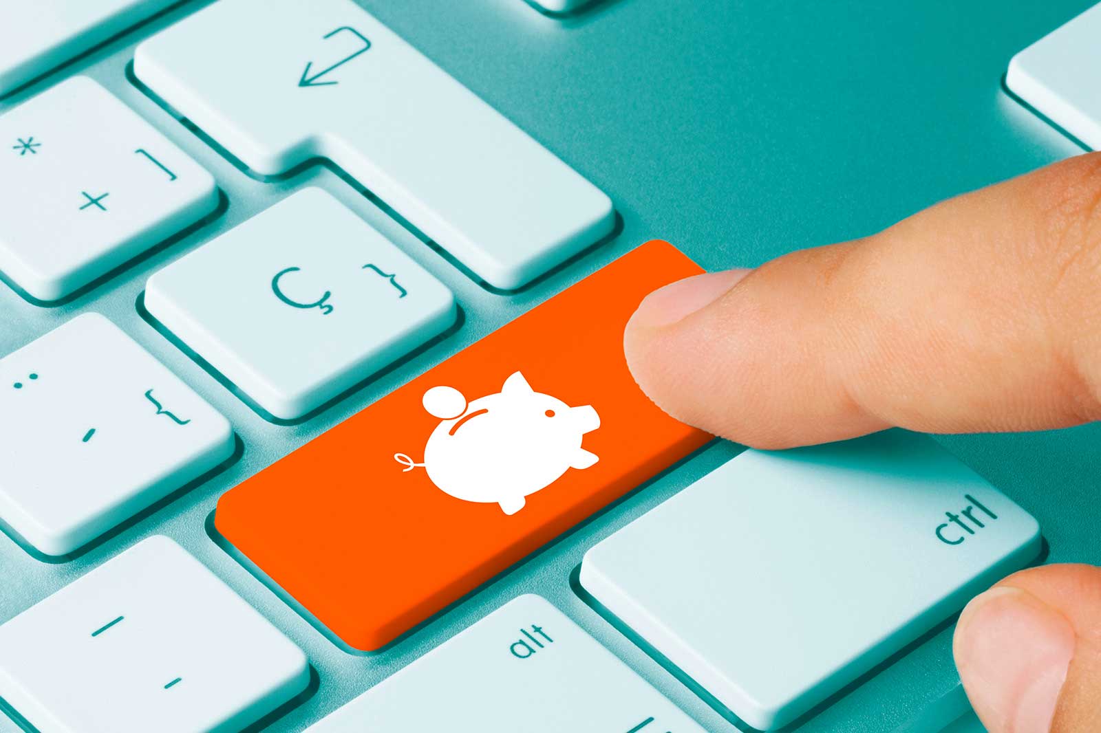A hand presses an orange key featuring a piggy bank symbol on a light blue keyboard.