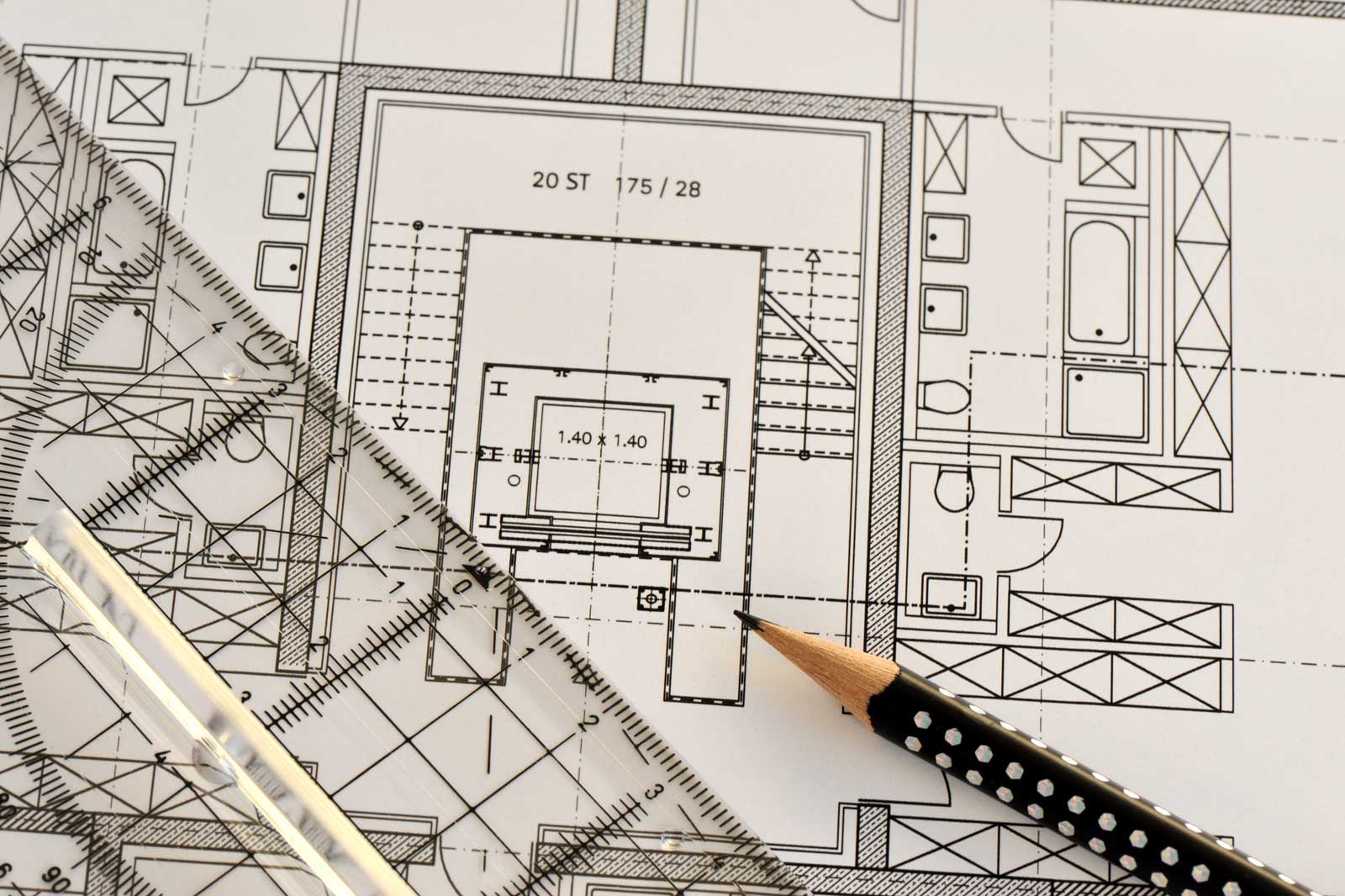 Ein detaillierter architektonischer Grundriss mit Maßen und einem Bleistift auf einer flachen Oberfläche, der Raumlayouts und Merkmale zeigt.