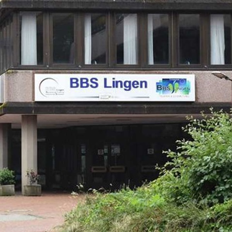 Ansicht des Gebäudes BBS Lingen mit auffälliger Beschilderung, umgeben von Pflanzen.