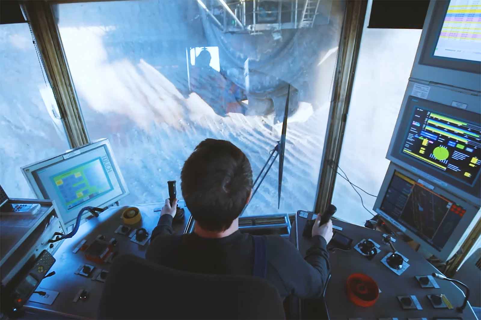 Eine Person bedient ein Steuerpanel in einer Maschinenkabine und konzentriert sich auf die bevorstehende Aufgabe.
